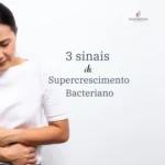 Mulher preocupada mostra sinais de supercrescimento bacteriano em postagem sobre saúde digestiva.